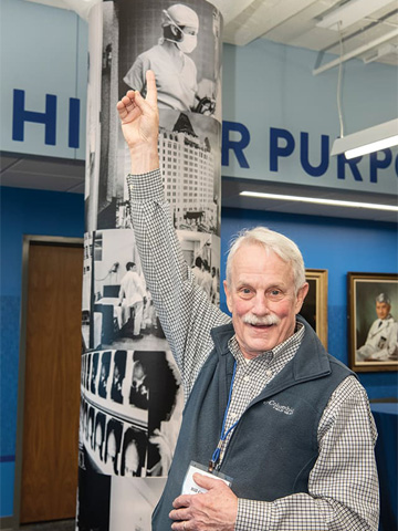 Medical School Alumni pointing at a younger picture of himself during the surgery wall dedication Medical School Alumni pointing at a younger picture of himself during the surgery wall dedication